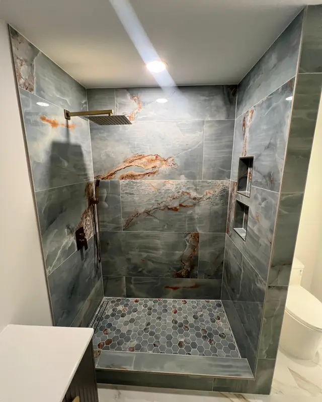 Shower with blue marble-look slabs and a recessed niche