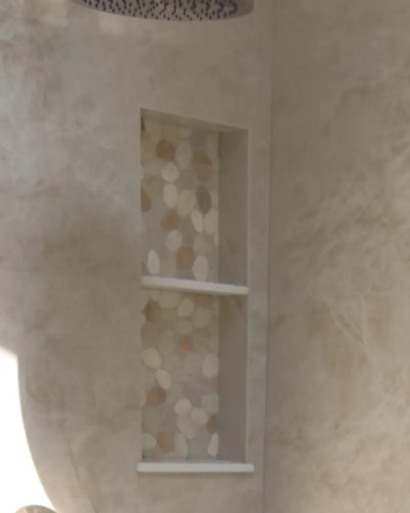 Two-shelf shower niche lined with pebble tile
