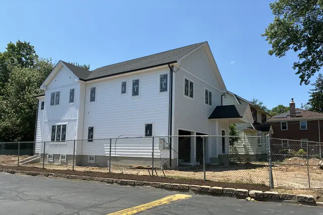 New two-story home with white siding built by GUS SKYY