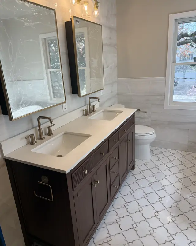 Dark wood double vanity with a white top, two mirrors and brushed faucets