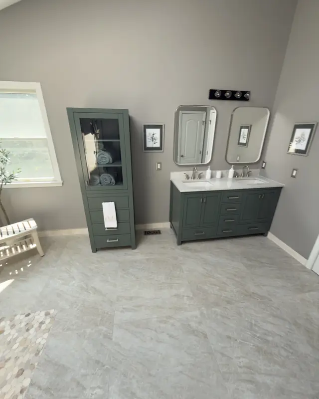 Green linen cabinet and double vanity by a window